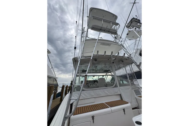 Slide: The Image of 2004 Cabo 40 Hardtop Express boat with tower, docked under cloudy skies. - 6