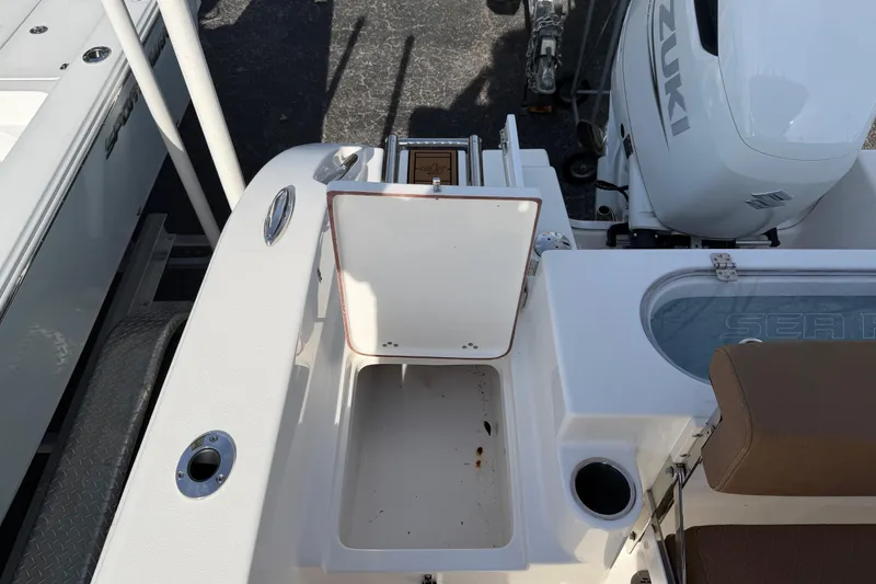 Slide: The Image of 2023 Sea Pro 239 Deep V CC boat with open storage compartment and Suzuki outboard motor. - 17