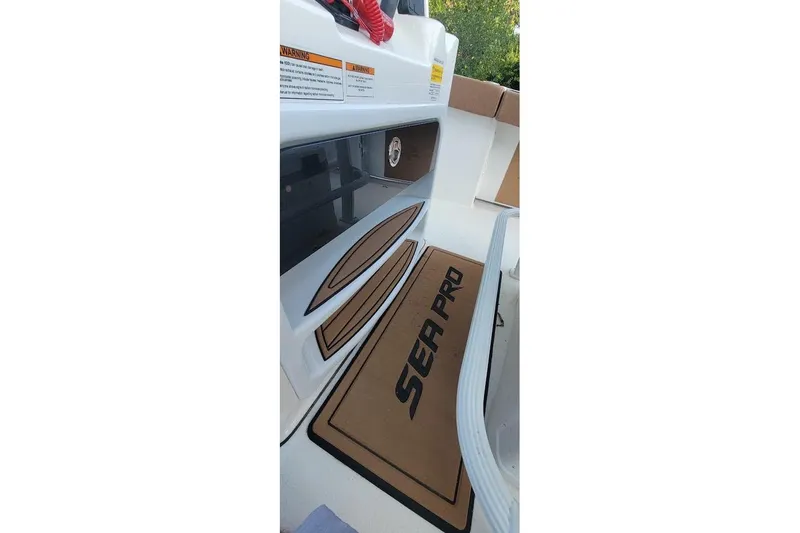 Slide: The Image of 2023 Sea Pro 239 Deep V CC boat interior with branded mat and storage compartments. - 4