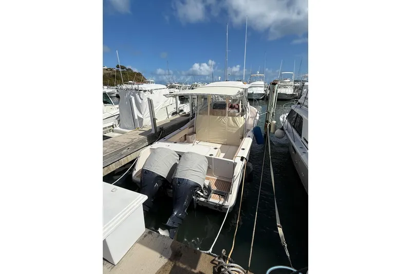 The Image of 2008 Grady-White Marlin 300 boat docked at a marina under a clear blue sky. - 1