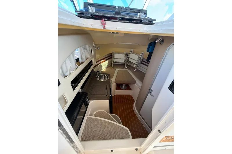 Slide: The Image of 2008 Grady-White Marlin 300 cabin interior with kitchenette and seating area. - 12