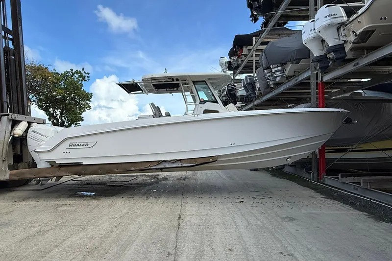 The Image of 2016 Boston Whaler 330 Outrage boat on forklift, marina storage background. - 1