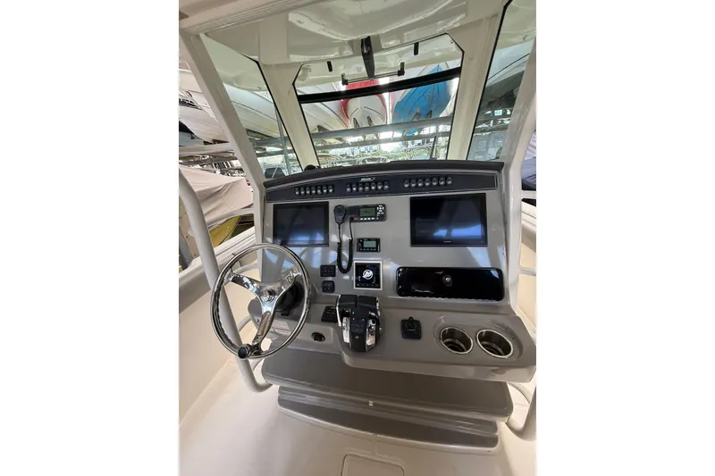 Slide: The Image of 2016 Boston Whaler 330 Outrage helm with steering wheel, controls, and navigation displays. - 7