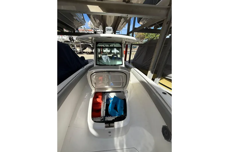 Slide: The Image of 2016 Boston Whaler 330 Outrage boat with open storage compartment, docked under cover. - 9