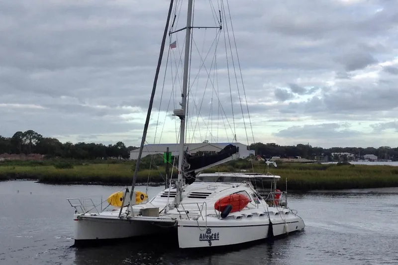 Slide: The Image of 2004 Island Spirit 400 catamaran sailing on a calm river under cloudy skies. - 0