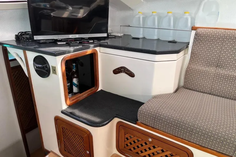 Slide: The Image of Interior of 2004 Island Spirit 400 yacht with TV, storage, and seating area. - 15