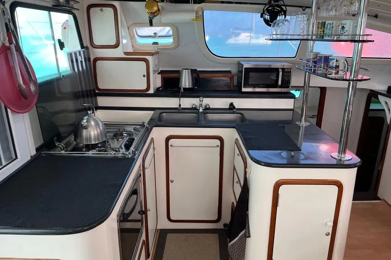 Slide: The Image of Compact kitchen in a 2004 Island Spirit 400 yacht, featuring stove, sink, and microwave. - 16