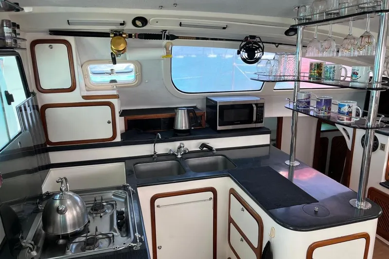 Slide: The Image of Modern kitchen in a 2004 Island Spirit 400 yacht with appliances and glassware. - 18