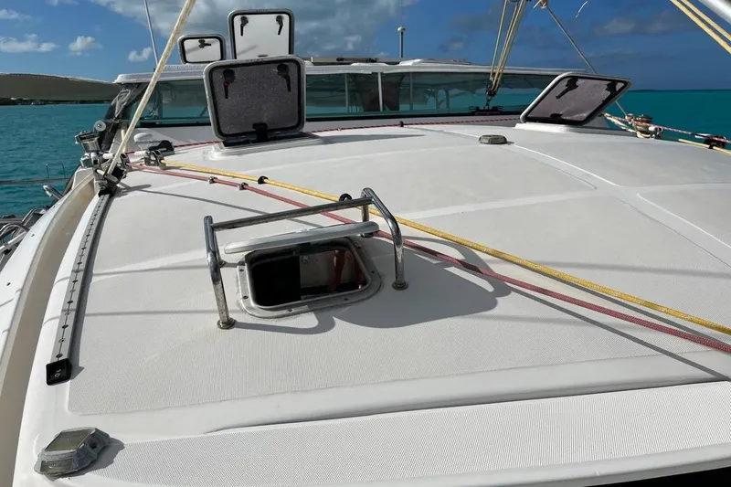 Slide: The Image of 2004 Island Spirit 400 yacht deck with open hatches, sailing on turquoise waters. - 25