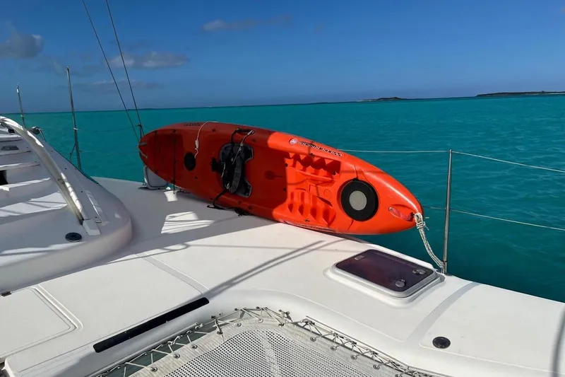 Slide: The Image of Orange kayak on 2004 Island Spirit 400 catamaran, turquoise sea background. - 30