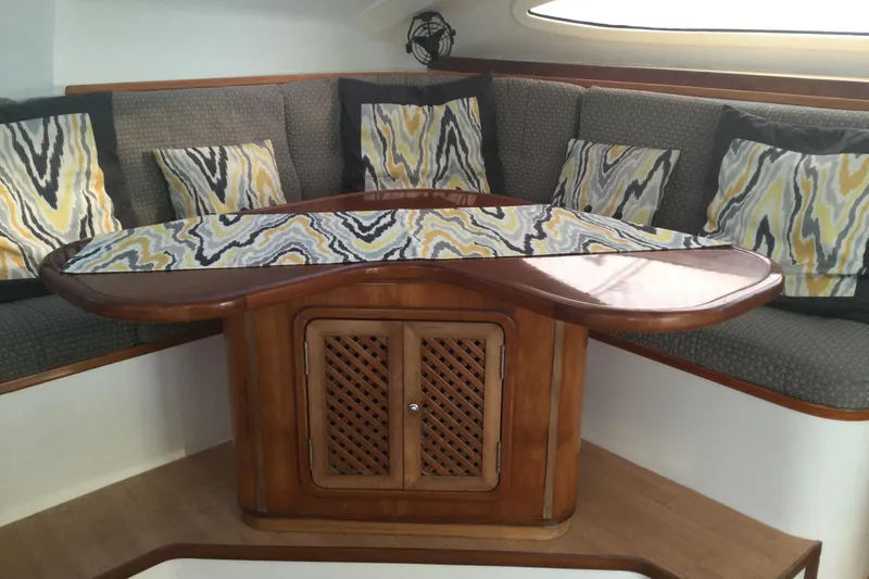 Slide: The Image of Cozy seating area on 2004 Island Spirit 400 yacht with patterned cushions and wooden table. - 5