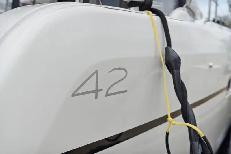 Slide: The Image of 2019 Lagoon 42 catamaran with outboard motor and teak deck. - 15
