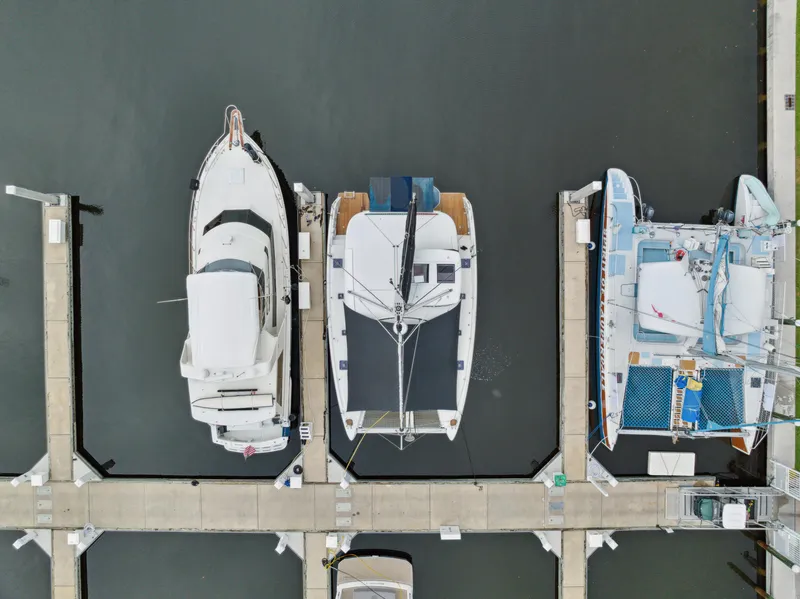 Slide: The Image of Aerial view of three boats docked, including a 2019 Lagoon 42. - 6