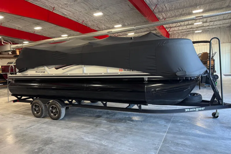 Slide: The Image of 2022 Ranger 223FC pontoon boat with cover on trailer in indoor storage. - 12