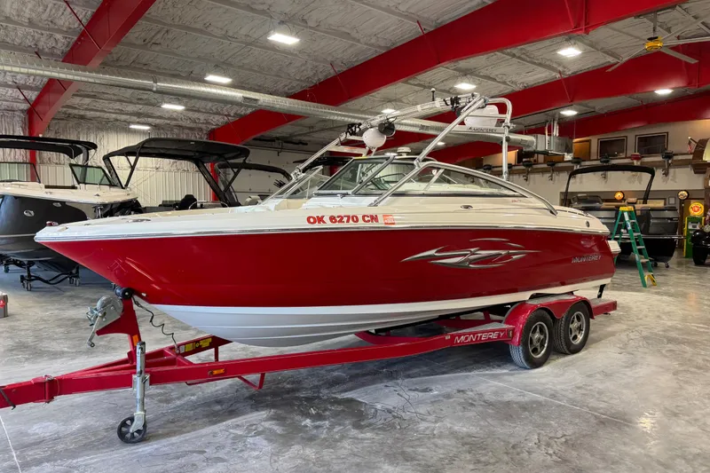 The Image of Red 2006 Monterey 234FS boat on trailer in indoor storage facility. - 1
