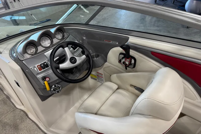 Slide: The Image of Interior of a 2006 Monterey 234FS boat showing steering wheel and dashboard controls. - 12