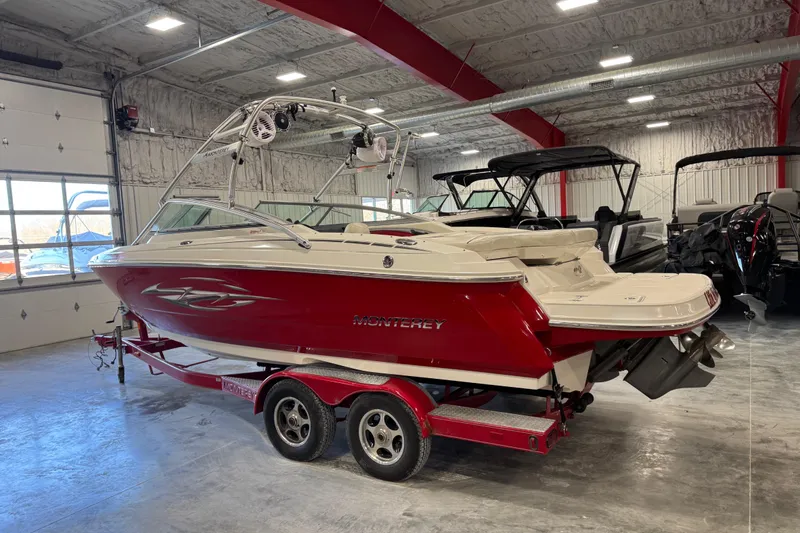 Slide: The Image of 2006 Monterey 234FS boat in a garage, red and white design, on a trailer. - 3