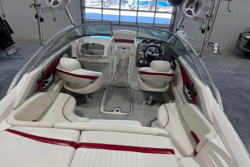 Slide: The Image of 2006 Monterey 234FS boat interior with white and red seating, steering wheel, and dashboard. - 6