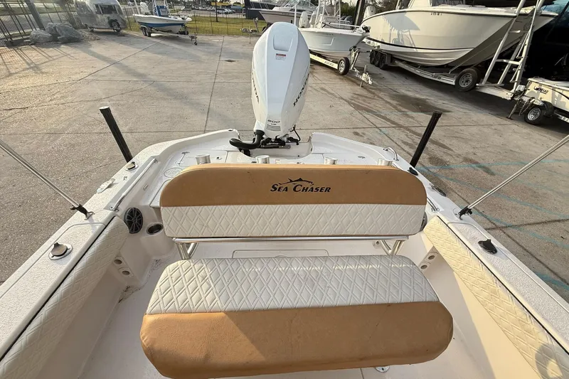 Slide: The Image of 2026 Sea Chaser 23 LX boat interior with seating and motor, docked outdoors. - 10