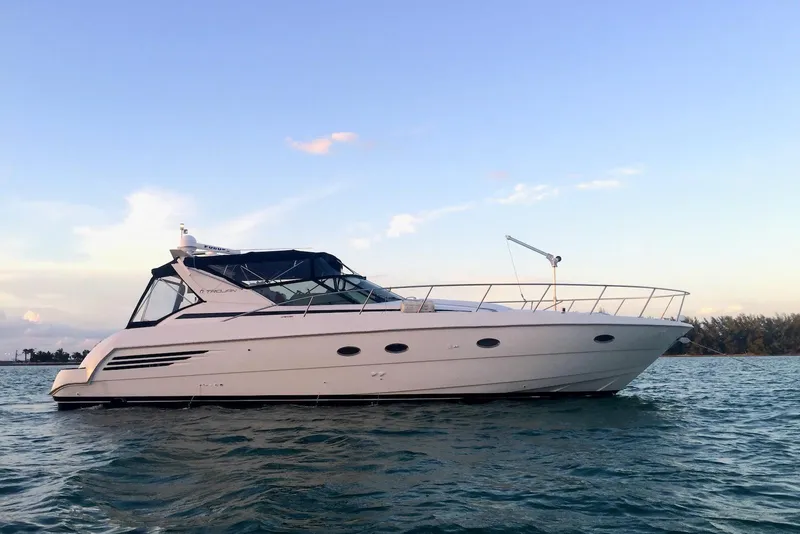 The Image of 1996 Trojan 440 Express Yacht on calm water at sunset. - 0