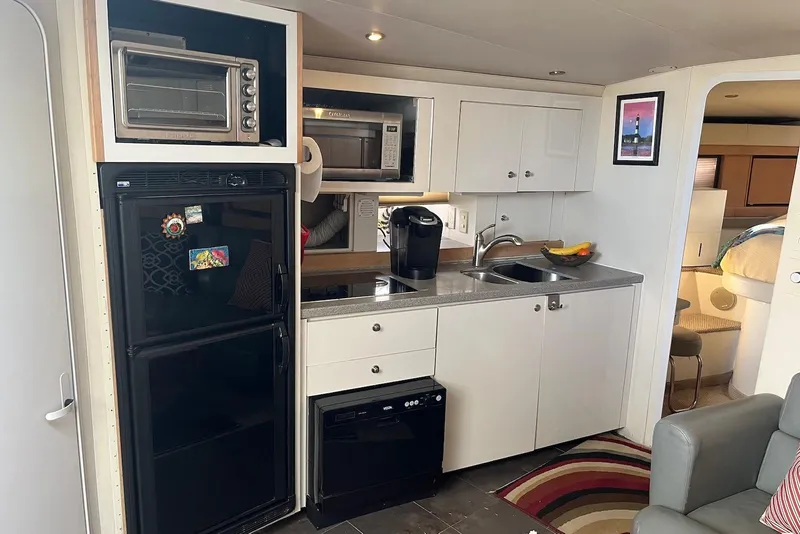 Slide: The Image of Interior of 1996 Trojan 440 Express Yacht with seating and mounted screen. - 10