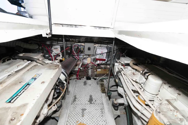 Slide: The Image of Engine room of a 1996 Trojan 440 Express Yacht, showcasing mechanical components and wiring. - 21