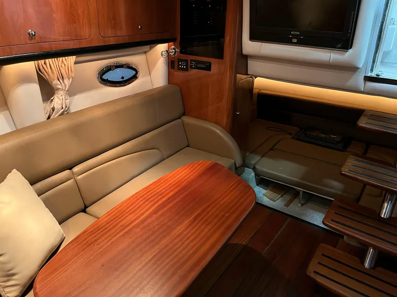 Slide: The Image of Interior of a 2011 Crownline 350 CR yacht with leather sofa and wooden table. - 16