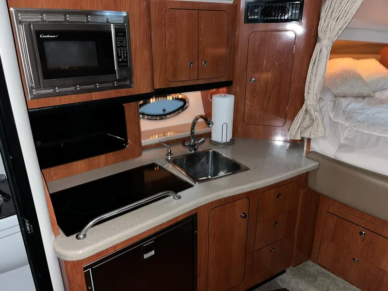Slide: The Image of Interior of 2011 Crownline 350 CR with kitchen and sleeping area. - 21