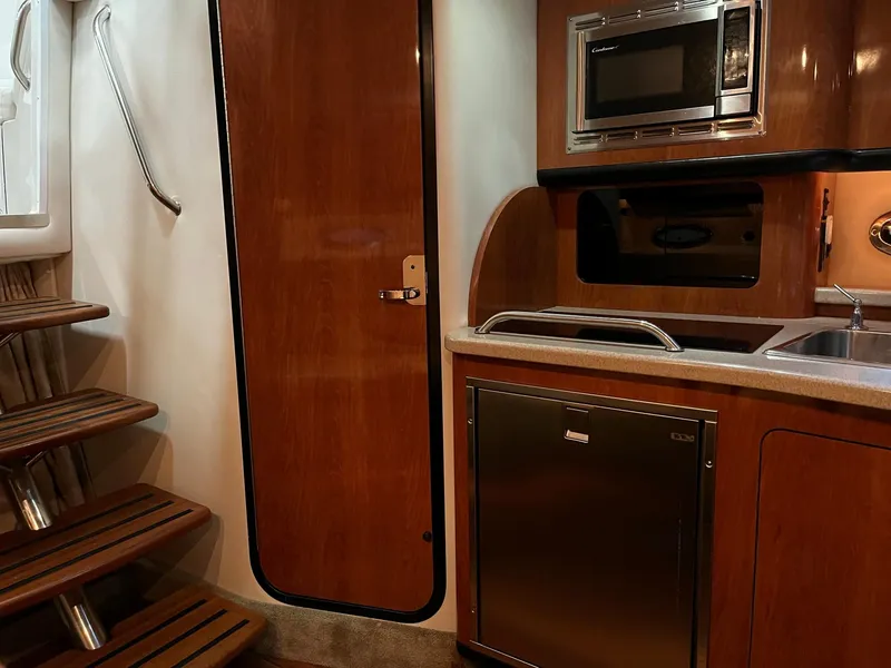 Slide: The Image of Interior of 2011 Crownline 350 CR with kitchen and wood accents. - 24