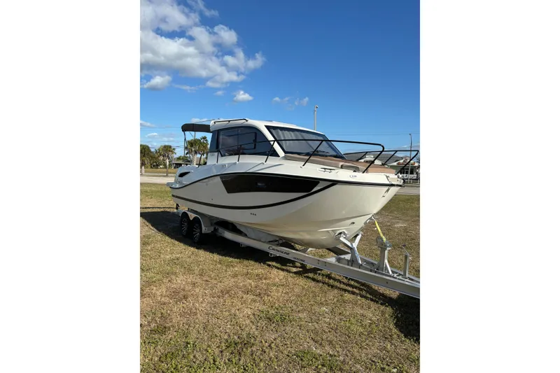 Slide: The Image of 2026 Trophy T 25 Explorer boat on trailer under clear blue sky. - 13