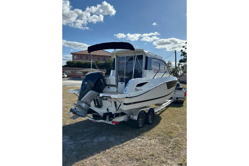 Slide: The Image of 2026 Trophy T 25 Explorer boat on trailer under clear sky. - 2