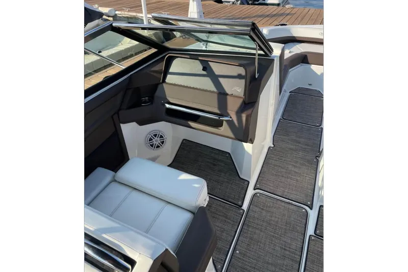 Slide: The Image of 2022 Cobalt R4 Outboard boat interior with seating and speaker, docked on wooden pier. - 6