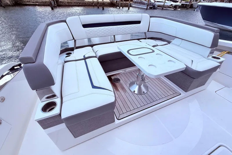 Slide: The Image of Luxurious seating area on 2022 Tiara Yachts 38 LS, featuring a stylish table and cup holders. - 2
