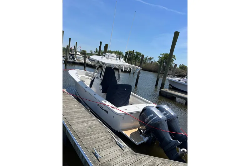 The Image of 2019 Regulator 25 boat docked with twin Yamaha engines, clear sky background. - 0