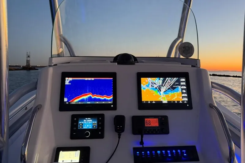Slide: The Image of 2019 Regulator 25 boat dashboard with navigation screens at sunset. - 11