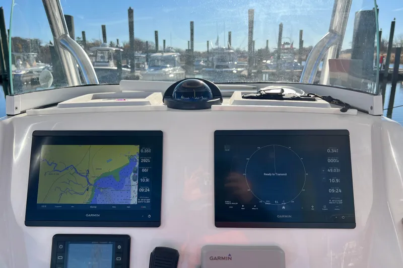 Slide: The Image of 2019 Regulator 25 boat dashboard with Garmin navigation screens at marina. - 12