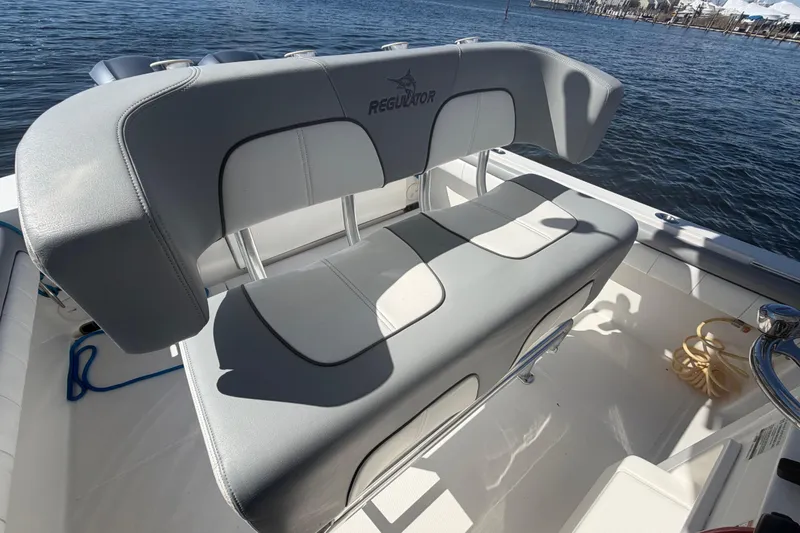 Slide: The Image of 2019 Regulator 25 boat interior storage compartment with cushioned seating and stainless steel supports. - 19