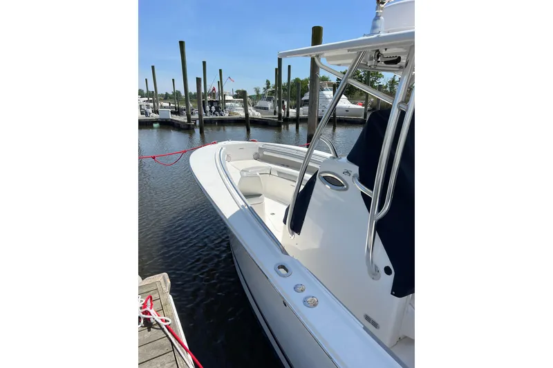 Slide: The Image of 2019 Regulator 25 boat docked at marina under clear blue sky. - 2