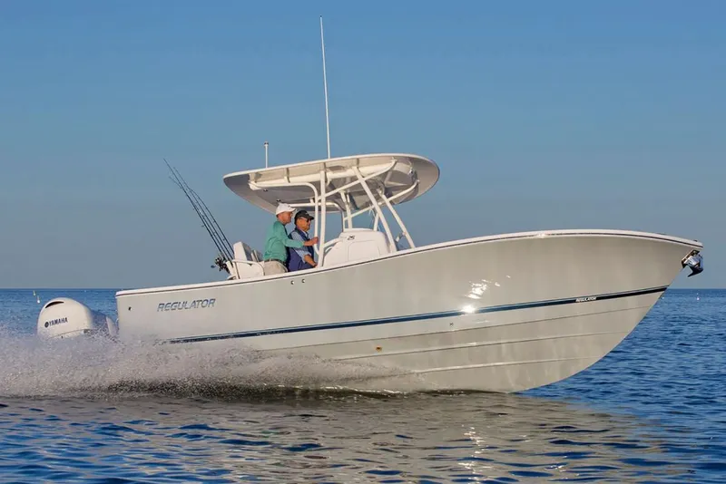 Slide: The Image of 2019 Regulator 25 boat on water near a bridge, showcasing sleek design and twin engines. - 3