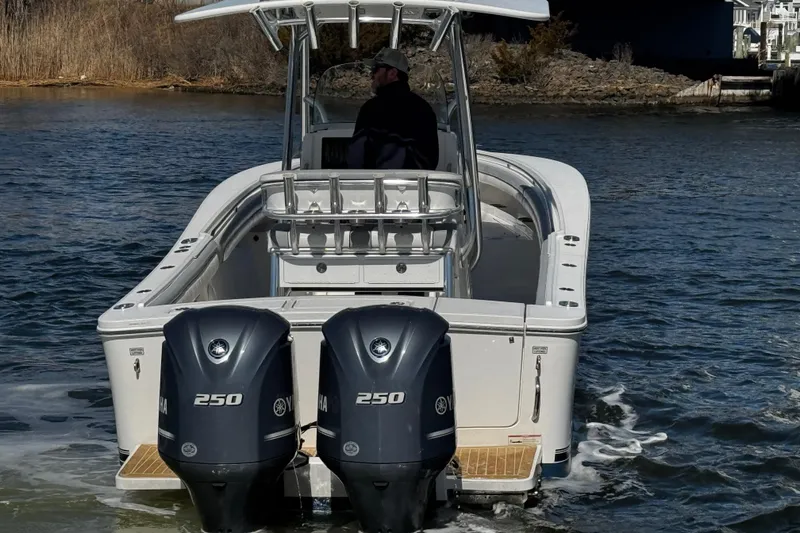 Slide: The Image of 2019 Regulator 25 boat interior with seating and console, docked at marina. - 45