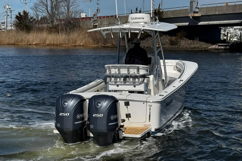 Slide: The Image of 2019 Regulator 25 boat docked, covered seats, dual engines, marina background. - 46