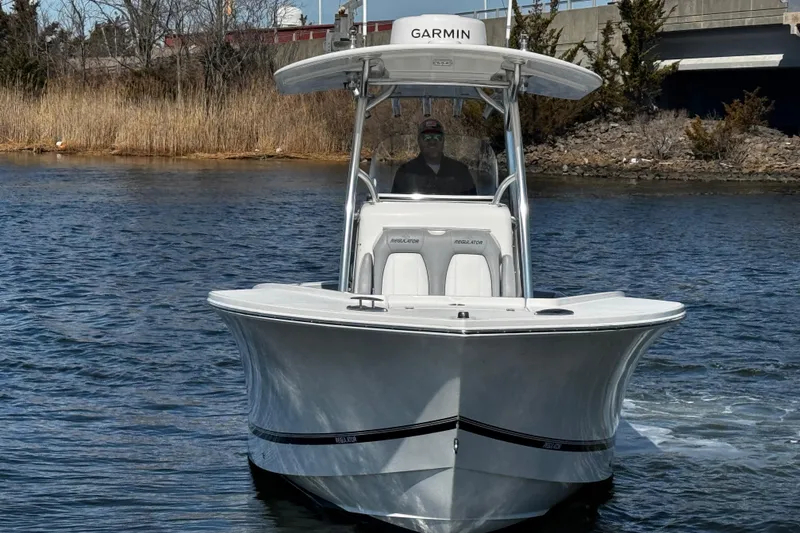 Slide: The Image of 2019 Regulator 25 boat interior with spacious seating and sleek design at a marina. - 55