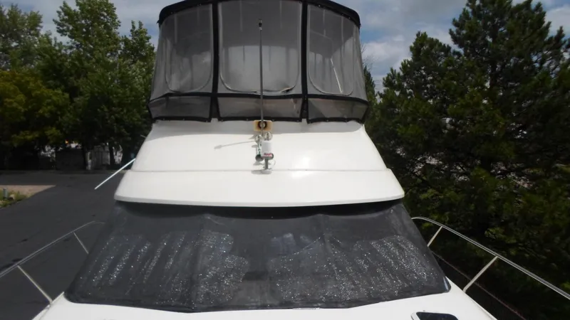 Slide: The Image of 1993 Silverton 37 Convertible yacht with canopy, surrounded by trees. - 7