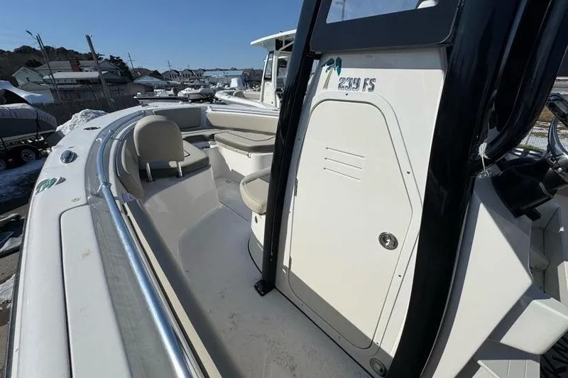 Slide: The Image of 2026 Key West 239 FS boat interior with seating and console, docked outdoors. - 19
