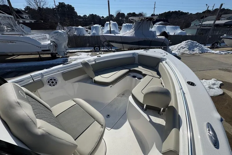 Slide: The Image of 2026 Key West 239 FS boat interior with cushioned seating, parked in snowy marina. - 24