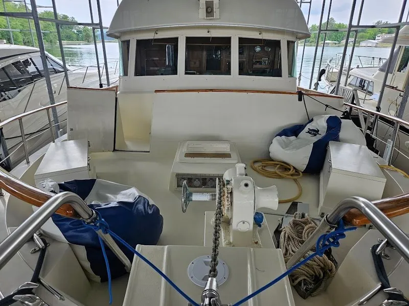 Slide: The Image of 1975 Hatteras 58L Long Range Cruiser with seating area by the water. - 16