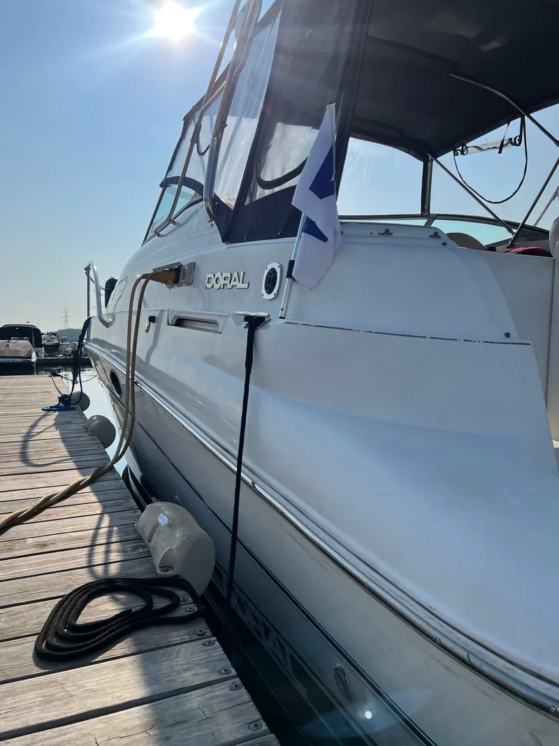 Slide: The Image of 1999 Doral 300 SC boat docked under sunny sky. - 6