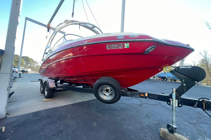 Slide: The Image of Red 2014 Yamaha Boats 242 Limited S on trailer, parked outdoors. - 6