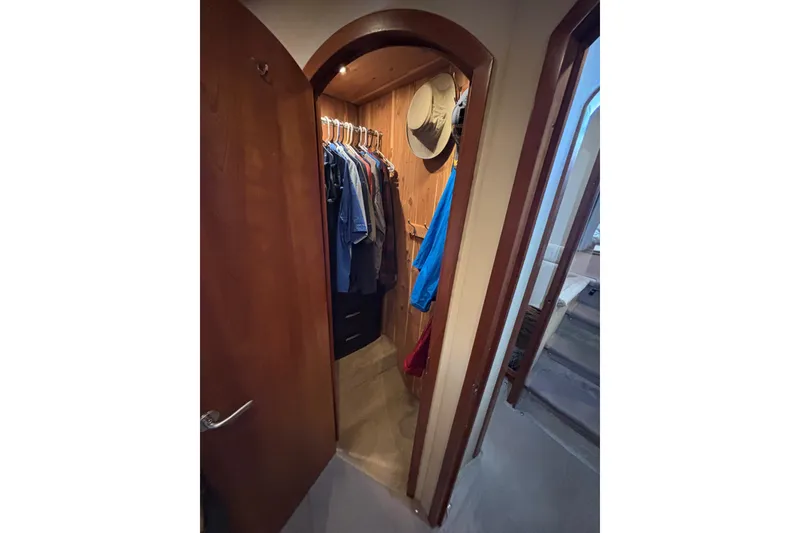 Slide: The Image of Walk-in closet on 2005 Cruisers Yachts 455 Express Motoryacht with hanging clothes and hats. - 18