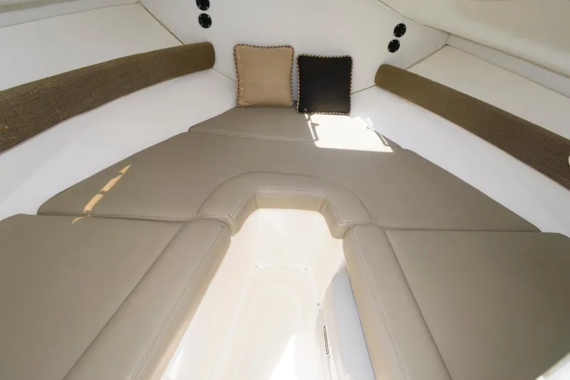 Slide: The Image of Interior cabin of 2001 Boston Whaler 23 Conquest with beige cushions and pillows. - 11